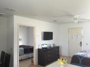 伊莎贝尔港岛港旅馆的一间卧室设有两张床,墙上配有电视。