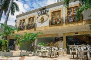 卡塔赫纳Hotel Virrey Cartagena的酒店前面的一排桌椅