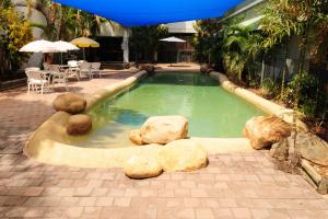 汤斯维尔阿伦酒店的游泳池设有岩石、桌子和遮阳伞