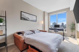 卡尔加里Heart of Downtown Calgary Spacious Luxury Condo with Stunning Views and Premium Amenities的一间卧室配有一张床、一张书桌和一个窗户。