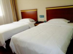南汇上海市浦东新区惠南镇城南路973号的配有白色床单的酒店客房内的两张床