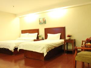 舟山格林豪泰浙江省舟山市新城商务酒店的一间卧室配有两张带白色床单和枕头的床。