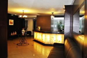 莫雷利亚Hotel Marcella Clase Ejecutiva的大堂设有带沙发和桌子的酒吧