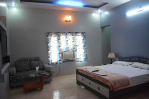 DarbhangaHotel Naveen Residency的一间卧室配有一张床、一张沙发和一个窗口