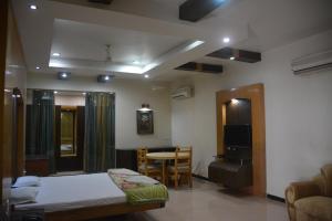 DarbhangaHotel Naveen Residency的卧室配有1张床、1张桌子和1把椅子