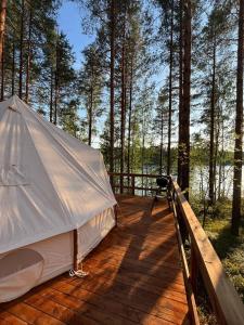 萨翁林纳Alaska Glamping Linnansaari的树林木甲板上的帐篷