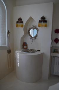 比塞大Dar Salama的浴室设有圆形浴缸和墙上的镜子