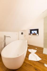 圣安东阿尔贝格Raffl's Sweet Little Home的浴室铺有木地板,配有白色浴缸。