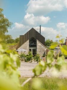 谢普顿马利特The Old Winery Cottage No1的一座黑色屋顶的石头建筑