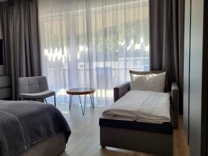 维斯瓦VISLOW Resort的一间卧室配有一张床、一张桌子和一个窗户。