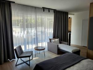 维斯瓦VISLOW Resort的一间卧室配有一张床、一张沙发和一把椅子