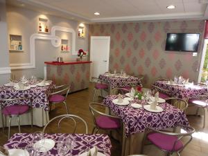 Zalamea de la SerenaHostal Calderón de la Barca的用餐室配有桌椅和紫色桌布