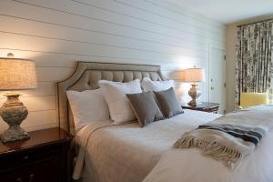 Lake ToxawayThe Greystone Inn的一间卧室配有一张带枕头的床和两盏灯。