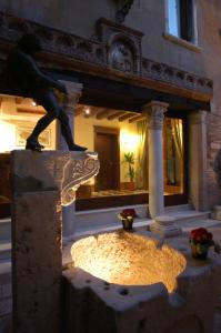 威尼斯阿尔蓬特默西尼果酒店的站在建筑物顶上的男人的雕像