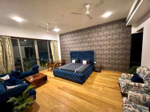 古尔冈luxury master bedroom with bathtub on golf course road的客厅配有1张床和2张沙发