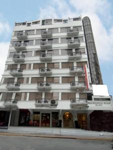 马尼拉Stone House Hotel Manila的带阳台的高高的白色建筑