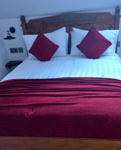 BessbrookDerrywilligan Guest Accommodation的一张带红色和白色枕头的床