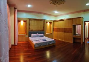 诗巫R&S Homestay Sibu - Wedding House with Large Parking Area and High Speed Unifi的一间卧室配有一张床,铺有木地板