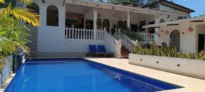 梅尔加Villa Clara Casa Campestre, Piscina, Naturaleza, Paseo de Río的房屋前有游泳池的房子