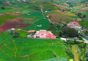 乌提Silent Valley Farm Resort Ooty by VOYE HOMES的田野农场的空中景观