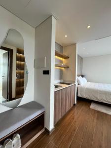 绥和市Kira Kira 's Apartment, Apec Mandala Phu Yen Condotel的一间卧室配有床、水槽和镜子