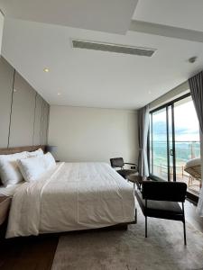 绥和市Kira Kira 's Apartment, Apec Mandala Phu Yen Condotel的卧室设有一张白色大床和一扇窗户。
