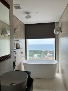 绥和市Kira Kira 's Apartment, Apec Mandala Phu Yen Condotel的带浴缸的浴室和大窗户