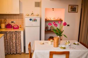 曼杜里亚Corte Schiavoni B&B的厨房配有桌子和白色冰箱。