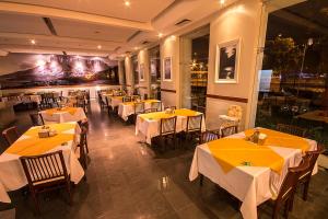 博阿维斯塔艾帕纳广场酒店的餐厅设有桌椅和黄色桌布