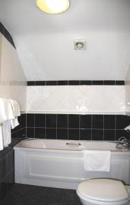 Greystoke长靴&鞋子旅馆的浴室配有白色卫生间和浴缸。