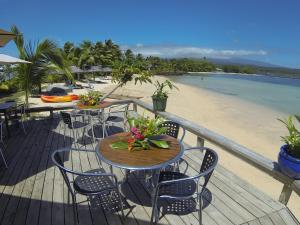 FagamaloSavaii Lagoon Resort的海滩上带桌椅的木制甲板