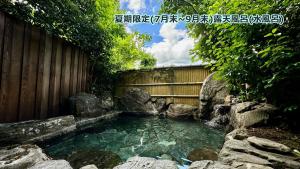 由布市湯布院 星の里 Yufuin Hoshinosato的围栏前的水池