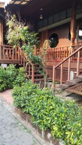 安帕瓦鲁恩麦差科隆度假酒店的一座带木楼梯和绿树丛的房子