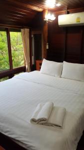 安帕瓦鲁恩麦差科隆度假酒店的一张带毛巾的白色床,设有窗户