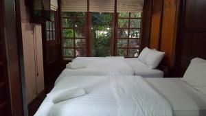 安帕瓦鲁恩麦差科隆度假酒店的带窗户的客房内的3张白色床