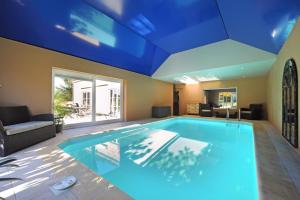艾瓦耶La Couette de l'Ours的一座拥有蓝色天花板的大型游泳池