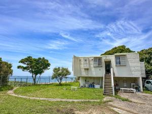 南部町秘境カフェ千里の浜的一座在海洋前有楼梯的建筑