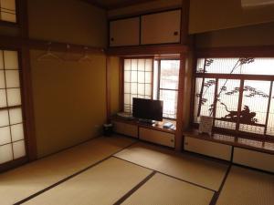平泉町平泉飞翔生活住宿加早餐旅馆的一间空房间,设有两个窗户和电视