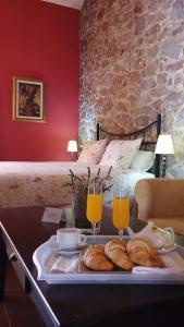 阿拉色那Hotel La Era de Aracena - Adults Only的托盘,包括面包和两杯橙汁