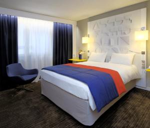 雷恩雷恩中心国会大厦美居酒店的酒店客房带一张大床和一把椅子