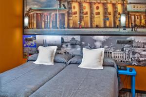 马德里JC客房圣多明各酒店的一间卧室配有带2个枕头的床