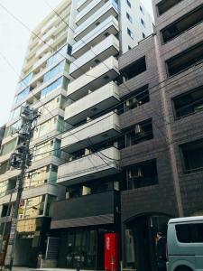 东京LANG - Vacation STAY 22203v的城市街道上一座高大的建筑,有面包车