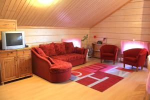 拉帕湖Koskikievari的客厅配有红色的沙发和两把椅子