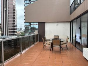 檀香山Downtown 2BR Huge Patio Free parking WiFi的大楼内的阳台配有桌椅