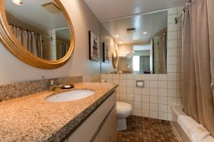 温哥华斯坦利罗斯伦套房酒店的一间带水槽、镜子和卫生间的浴室