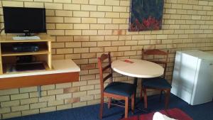 楠伯南博中央汽车旅馆的配有桌椅和电视的客房