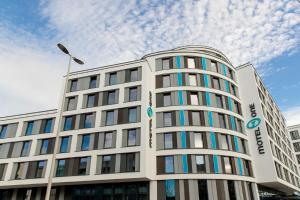 波恩Motel One Bonn-Beethoven的一座高大的白色建筑,背后是天空