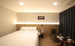 济州市海港酒店的酒店的客房配备了一张床、一张书桌和一部电话。