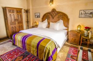 拉巴特里亚德西迪法塔赫酒店的一间卧室配有一张大床和木制床头板