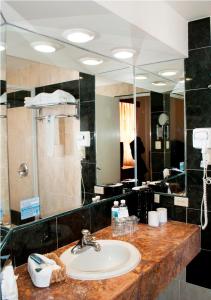 莫雷利亚Hotel Marcella Clase Ejecutiva的一间带水槽和大镜子的浴室
